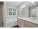 Bathroom featuring soaking tub, double sinks, and a large mirror at 46 Highland Ct, Carrollton, GA 30116