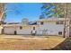 Back exterior of home with a patio and spacious backyard surrounded by mature trees at 6071 Cristie Dr, Ellenwood, GA 30294