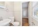 Bright bathroom with a white pedestal sink, toilet, and beadboard wall accents at 6071 Cristie Dr, Ellenwood, GA 30294