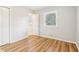An empty bedroom with wood-look floors and bright white trim, window, and closet at 6071 Cristie Dr, Ellenwood, GA 30294