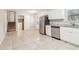 Well-lit kitchen with stainless steel appliances, white cabinets, and tile flooring at 6071 Cristie Dr, Ellenwood, GA 30294