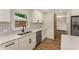 Bright kitchen with white cabinets, modern appliances, and stylish tile backsplash at 1364 Willis Mill Sw Rd, Atlanta, GA 30311