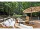 Relaxing backyard deck complete with comfortable seating, umbrella, and gas fire pit at 159 Cavan Se Way, Mableton, GA 30126