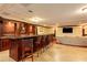 Elegant bar area featuring wood finishes, granite countertops, shelving, seating, and a mounted television at 3334 Peachtree Ne Rd # 1707, Atlanta, GA 30326