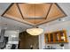 Contemporary kitchen showcasing a unique chandelier and decorative ceiling design above a kitchen island with barstool seating at 3334 Peachtree Ne Rd # 1707, Atlanta, GA 30326