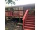 Red painted wooden deck with brick house and lush backyard at 4485 Merlin Ne Cir, Douglasville, GA 30134