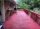 Back deck in need of repair with a red painted wood finish at 4485 Merlin Ne Cir, Douglasville, GA 30134