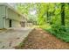 Exterior view of home with a concrete patio and backyard featuring mature trees at 4669 Birch Ridge Trl, Stone Mountain, GA 30083
