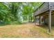 Backyard view of home with a wooden deck and stairs leading to the fenced yard and driveway at 4669 Birch Ridge Trl, Stone Mountain, GA 30083
