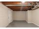 Unfinished basement area showcasing concrete block wall, painted floor and exposed ceiling at 4669 Birch Ridge Trl, Stone Mountain, GA 30083