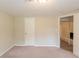 Bedroom view featuring a door, neutral walls, carpeted floor, and an open doorway to another room at 4669 Birch Ridge Trl, Stone Mountain, GA 30083