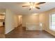 Bright living room features wood floors, a staircase, and a ceiling fan with light at 4669 Birch Ridge Trl, Stone Mountain, GA 30083
