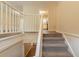 Carpeted staircase with white banister leading to the main floor and the kitchen at 4669 Birch Ridge Trl, Stone Mountain, GA 30083