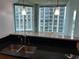 Kitchen features a granite counter, stainless sink and light fixtures near floor to ceiling windows at 361 17Th Nw St # 1303, Atlanta, GA 30363