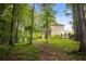 Serene backyard featuring lush greenery, mature trees, and a well-maintained lawn for peaceful outdoor enjoyment at 6435 Ivey Creek Cir, Cumming, GA 30040