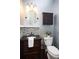 Powder room featuring dark vanity with black granite countertop, and tiled backsplash at 6435 Ivey Creek Cir, Cumming, GA 30040
