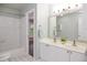 Bright bathroom features a double sink vanity, tub with tile surround, and a view to the outside at 6435 Ivey Creek Cir, Cumming, GA 30040