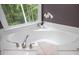 Corner soaking tub with a view of the woods at 6435 Ivey Creek Cir, Cumming, GA 30040