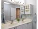 Bright bathroom features a double sink vanity, framed mirror and a small cabinet at 6435 Ivey Creek Cir, Cumming, GA 30040