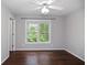 Empty bedroom features hardwood floors and a window letting in natural light at 6435 Ivey Creek Cir, Cumming, GA 30040