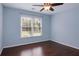 This is a blue bedroom with a window and dark hardwood floors at 6435 Ivey Creek Cir, Cumming, GA 30040