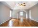 Spacious bedroom features a tray ceiling, ceiling fan, hardwood flooring, and ample natural light at 6435 Ivey Creek Cir, Cumming, GA 30040
