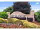 The 'Ivey Manor' brick sign is surrounded by colorful flowers and manicured landscaping, adding charm at 6435 Ivey Creek Cir, Cumming, GA 30040