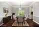 Staged dining room with seating for six, a decorative chandelier, and a view to the lush outdoor landscaping at 6435 Ivey Creek Cir, Cumming, GA 30040