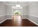 Empty dining room with hardwood floors, crown molding, and a bright view into an adjoining room with natural light at 6435 Ivey Creek Cir, Cumming, GA 30040