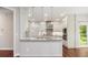 Modern kitchen featuring a breakfast bar with pendant lights, white cabinets, and stainless steel appliances at 6435 Ivey Creek Cir, Cumming, GA 30040