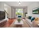 Cozy living room with large windows, hardwood floors, and neutral decor at 6435 Ivey Creek Cir, Cumming, GA 30040