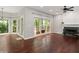 Open living room with hardwood floors, a stone fireplace, and large windows overlooking the deck and backyard at 6435 Ivey Creek Cir, Cumming, GA 30040