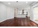 Open-concept room featuring hardwood floors, white walls, and a view into the updated kitchen with modern appliances at 6435 Ivey Creek Cir, Cumming, GA 30040