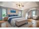 Bright main bedroom boasts a tray ceiling, ceiling fan, and a large bed with blue accents and an ensuite bathroom at 6435 Ivey Creek Cir, Cumming, GA 30040