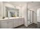 Bright bathroom featuring a double vanity, sleek lighting, and a glass-enclosed shower at 947 Edwin Ln, Sugar Hill, GA 30518