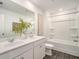 Well-lit bathroom with double sinks, large mirror, wood-look flooring, and a bathtub shower combo at 947 Edwin Ln, Sugar Hill, GA 30518