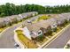 Aerial view showcasing a community of modern homes, tree-lined streets, and a glimpse of nearby green space at 947 Edwin Ln, Sugar Hill, GA 30518