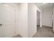 Well-lit hallway featuring carpet flooring, neutral paint, and a door leading to another room at 947 Edwin Ln, Sugar Hill, GA 30518