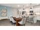 Stylish kitchen featuring white cabinetry, stainless steel appliances, and a dining area with modern lighting at 947 Edwin Ln, Sugar Hill, GA 30518