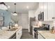 Modern kitchen with granite countertops, stainless steel appliances, and white cabinets adjacent to dining area at 947 Edwin Ln, Sugar Hill, GA 30518