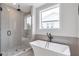 Modern bathroom features a glass shower and a soaking tub with black fixtures at 134 Everley Walk, Alpharetta, GA 30009