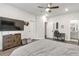 A spacious bedroom featuring a ceiling fan, wooden floors, a TV, and two doors at 134 Everley Walk, Alpharetta, GA 30009