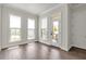 Bedroom featuring hardwood floors, white walls, natural light, and access to the outdoor patio at 134 Everley Walk, Alpharetta, GA 30009