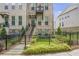 Brick townhome featuring a small balcony on the second floor, with a small front yard and fence at 134 Everley Walk, Alpharetta, GA 30009