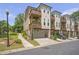 Beautiful townhome with a private balcony, attached garage, manicured lawn, and professional landscaping at 134 Everley Walk, Alpharetta, GA 30009