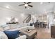 Open-concept living room showcases hardwood floors, a ceiling fan and leads to the kitchen and dining area at 134 Everley Walk, Alpharetta, GA 30009