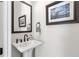 Powder room features a pedestal sink, dark accents, and decorative mirror at 134 Everley Walk, Alpharetta, GA 30009