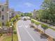 Street view of gated neighborhood featuring manicured landscaping, sidewalks, and elegant townhome exteriors at 134 Everley Walk, Alpharetta, GA 30009