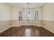 Sunlit bedroom with hardwood floors, neutral walls, and three windows offering bright and airy atmosphere at 1698 Bennett Dr, Mcdonough, GA 30253