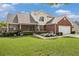 Beautiful two-story home with brick facade, lush lawn, and an American flag accenting the front garden at 1698 Bennett Dr, Mcdonough, GA 30253